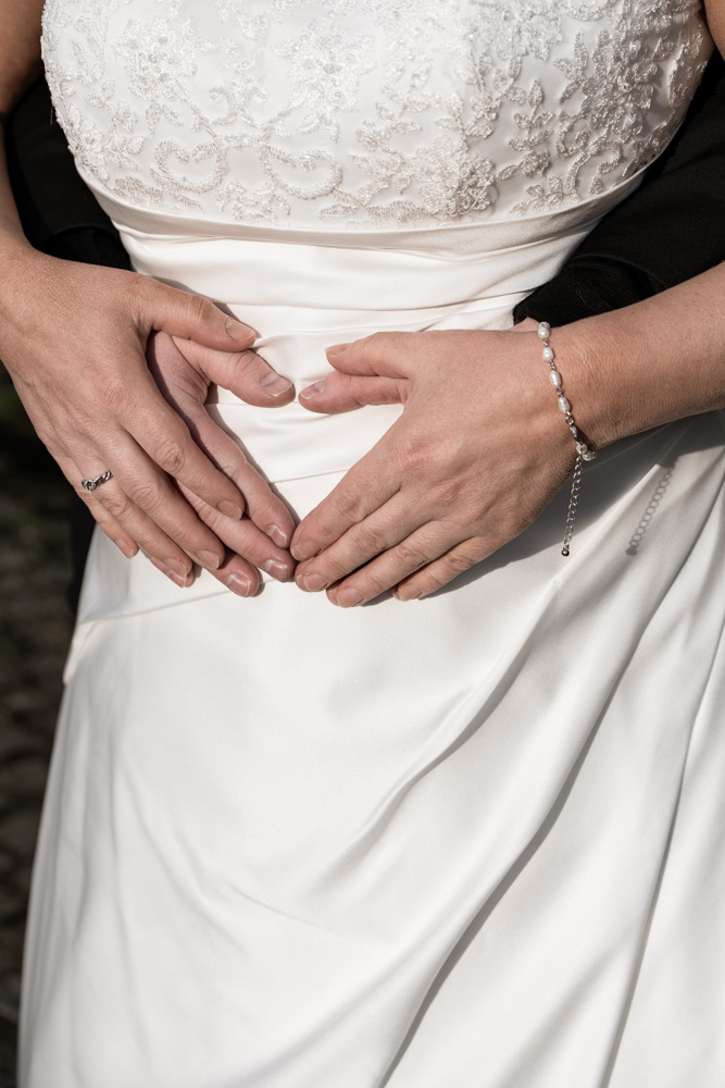 Bryllupsfoto af brudepars hænder der former et hjerte