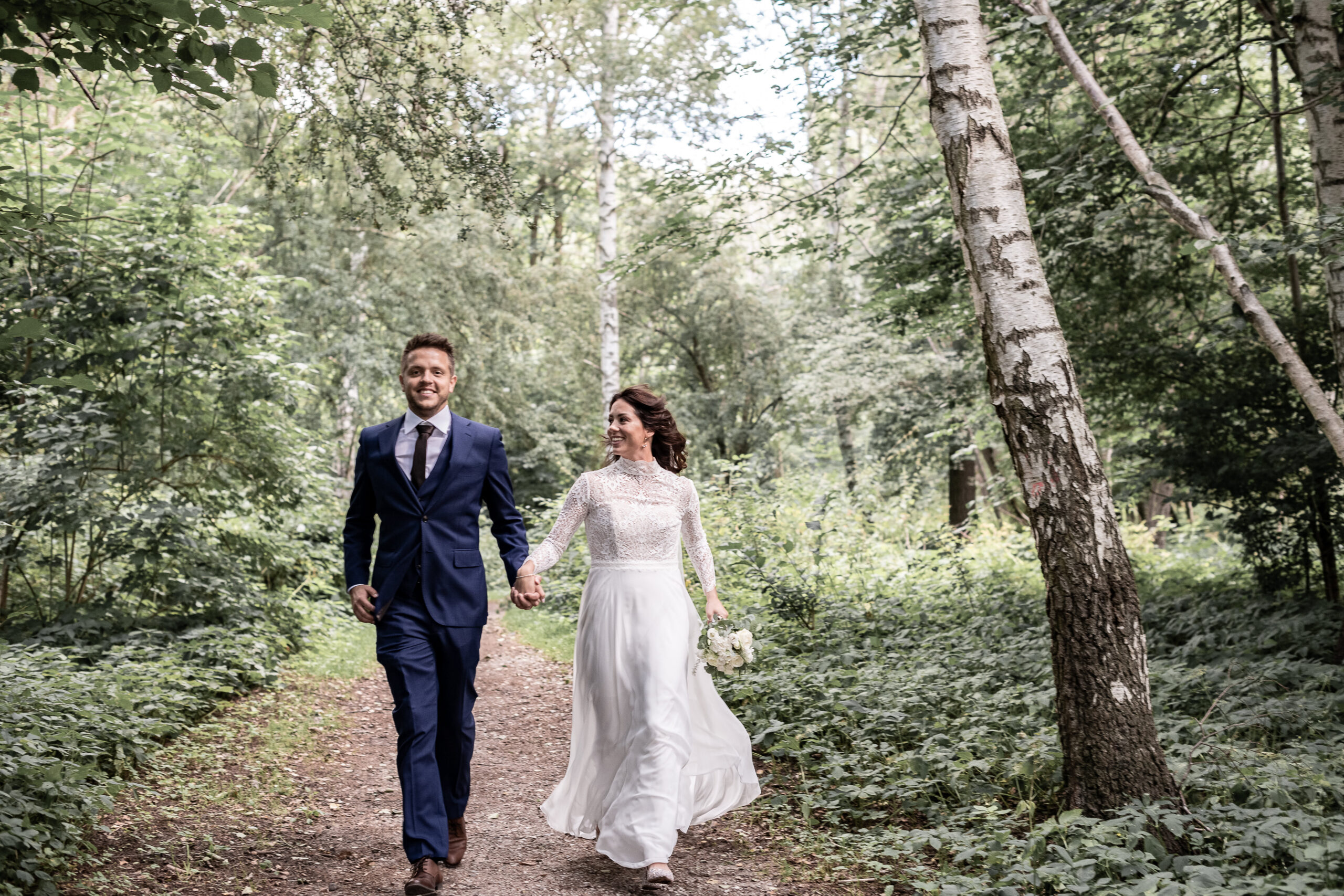 Bryllupsbilleder af brudepar der løber i skoven