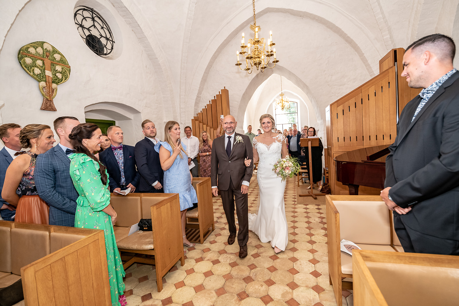 Bryllupsbillede af bruden der går op ad kirkegulvet med sin far